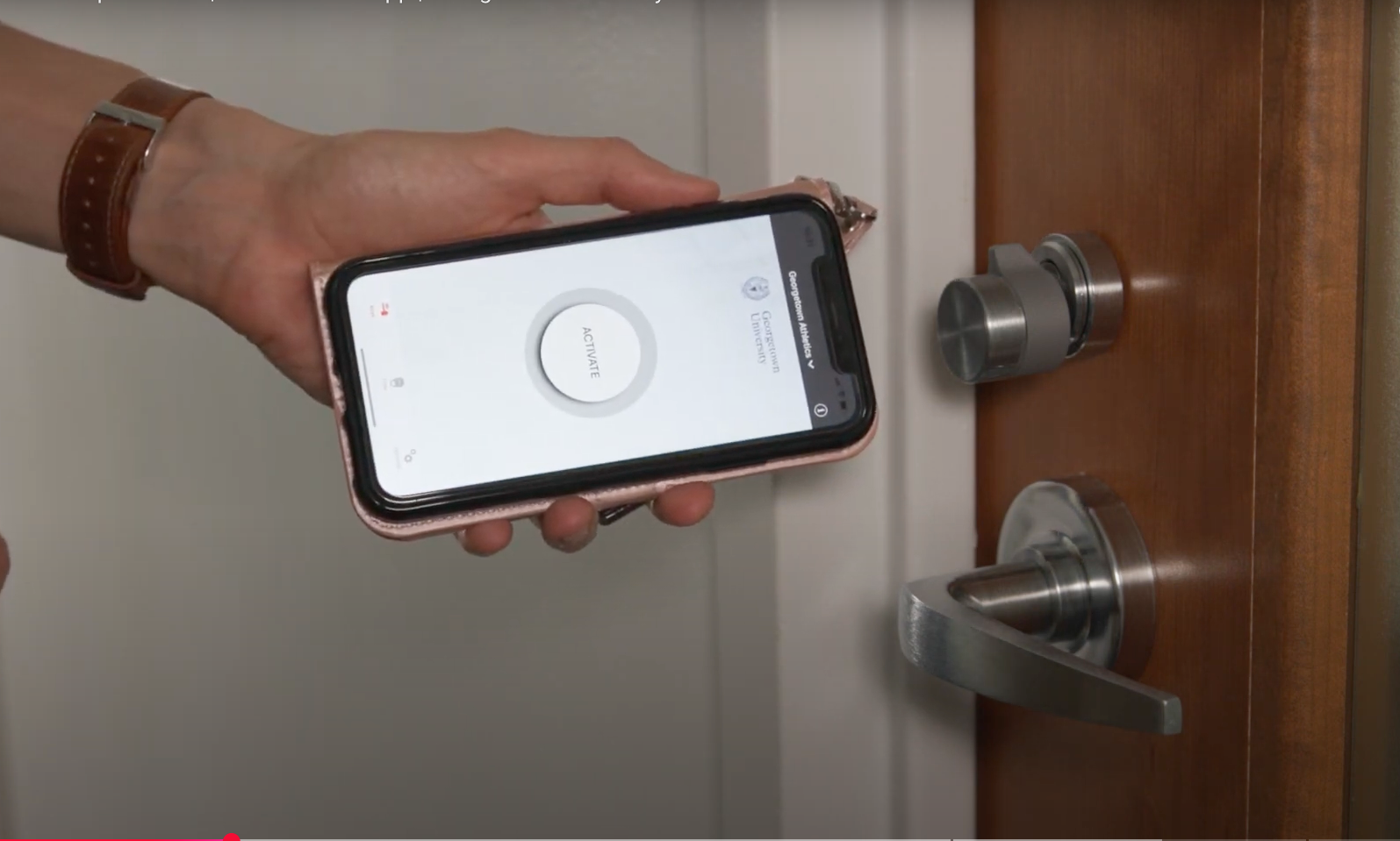 hand using an iPhone to unlock a door